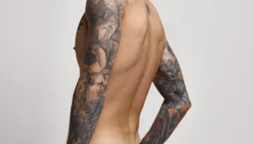 En mann med armene fulle av tatovering i forut for behandling med fjerning av tatovering med laser hos Remove hud- og laserklinikk.
